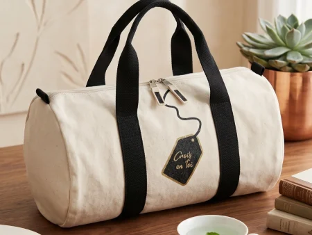 Sac bowling en toile tissée naturelle avec l'inscription Crois en toi, posé dans un environnement doux.